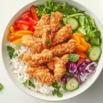 Crispy chicken rice bowl with veggies and mint sauce.